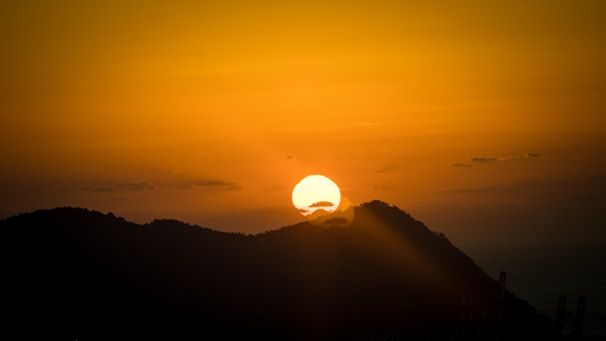 Sunset over the mountains surrounding Magé, casting warm golden light.