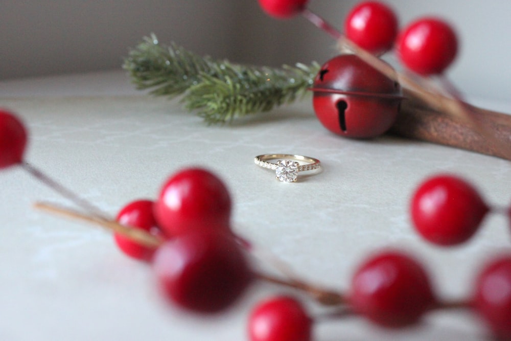 a ring on a table with red berries