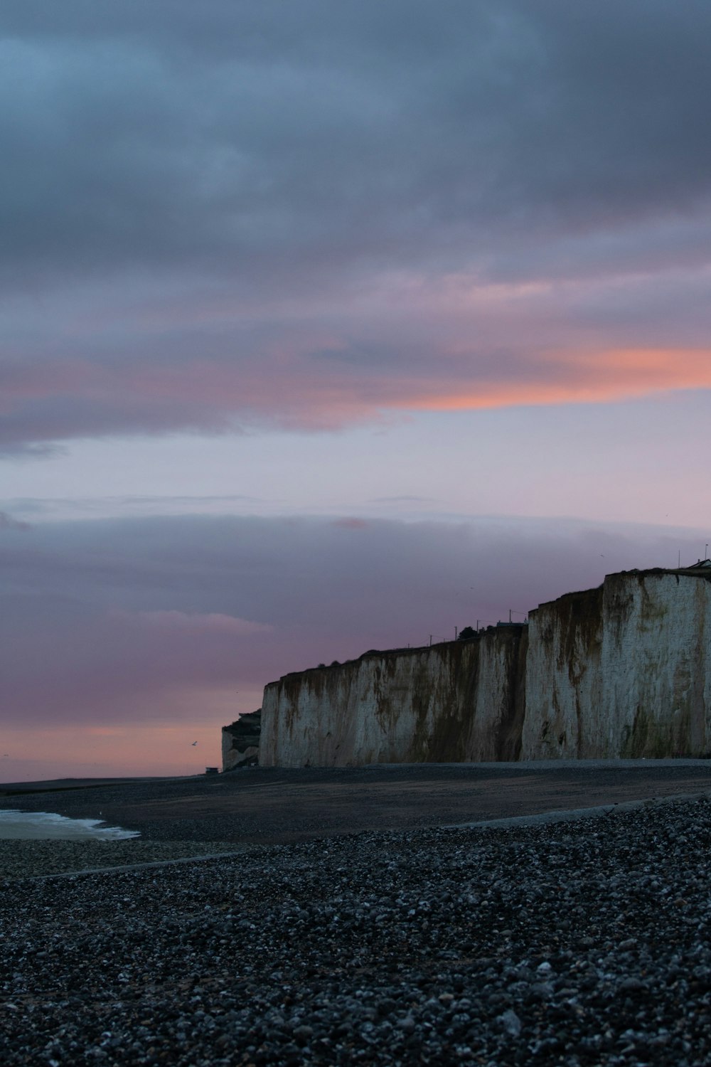 a rocky beach with a large cliff