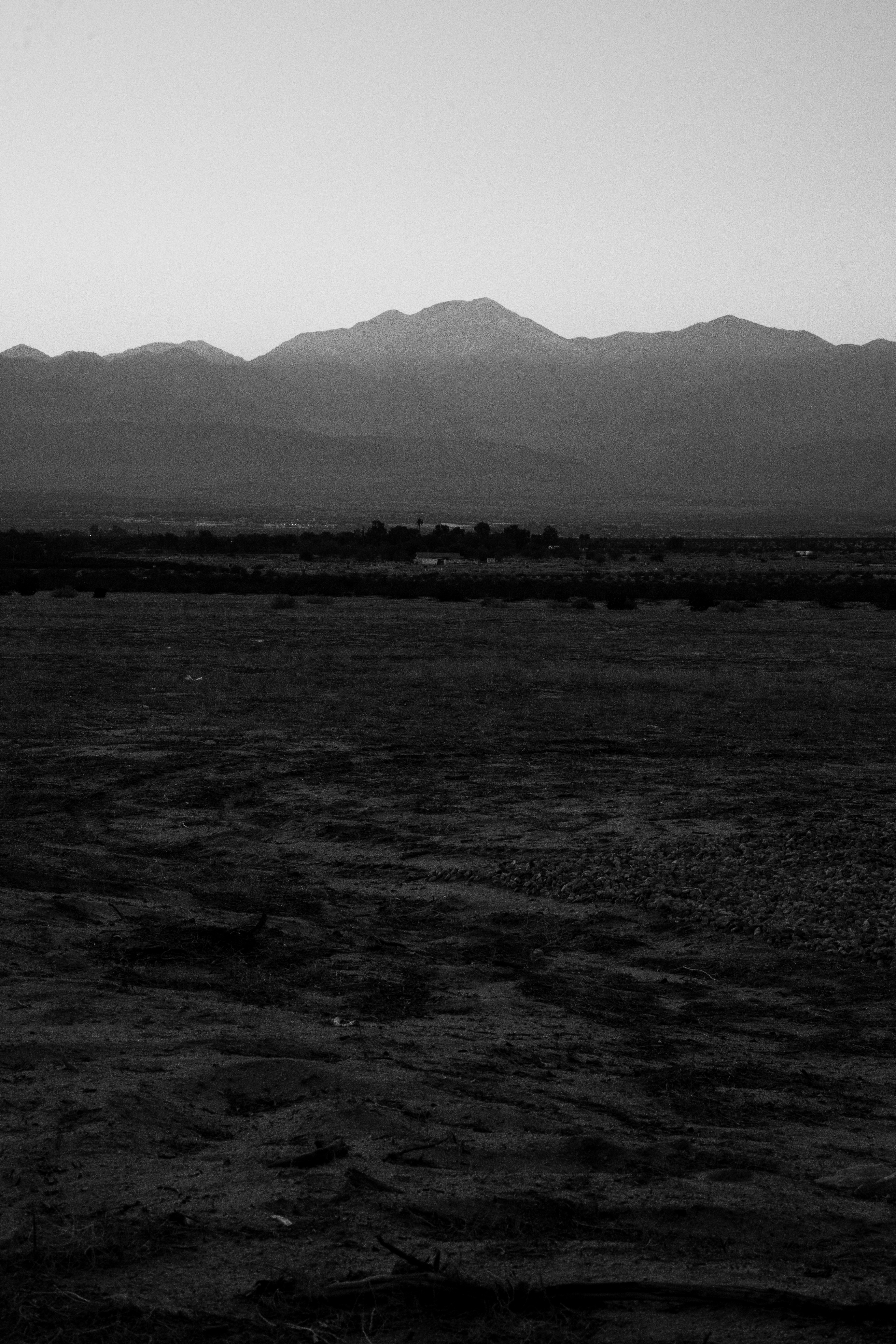 A large flat area with mountains in the background photo Free Palm
