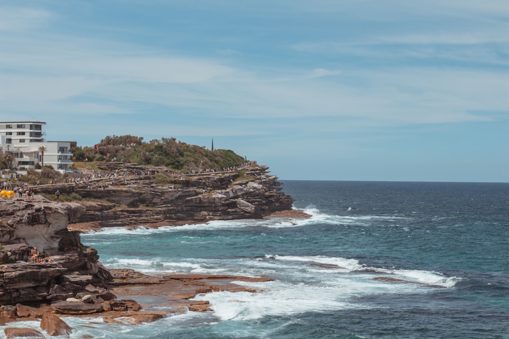 a rocky beach with a building on the shore