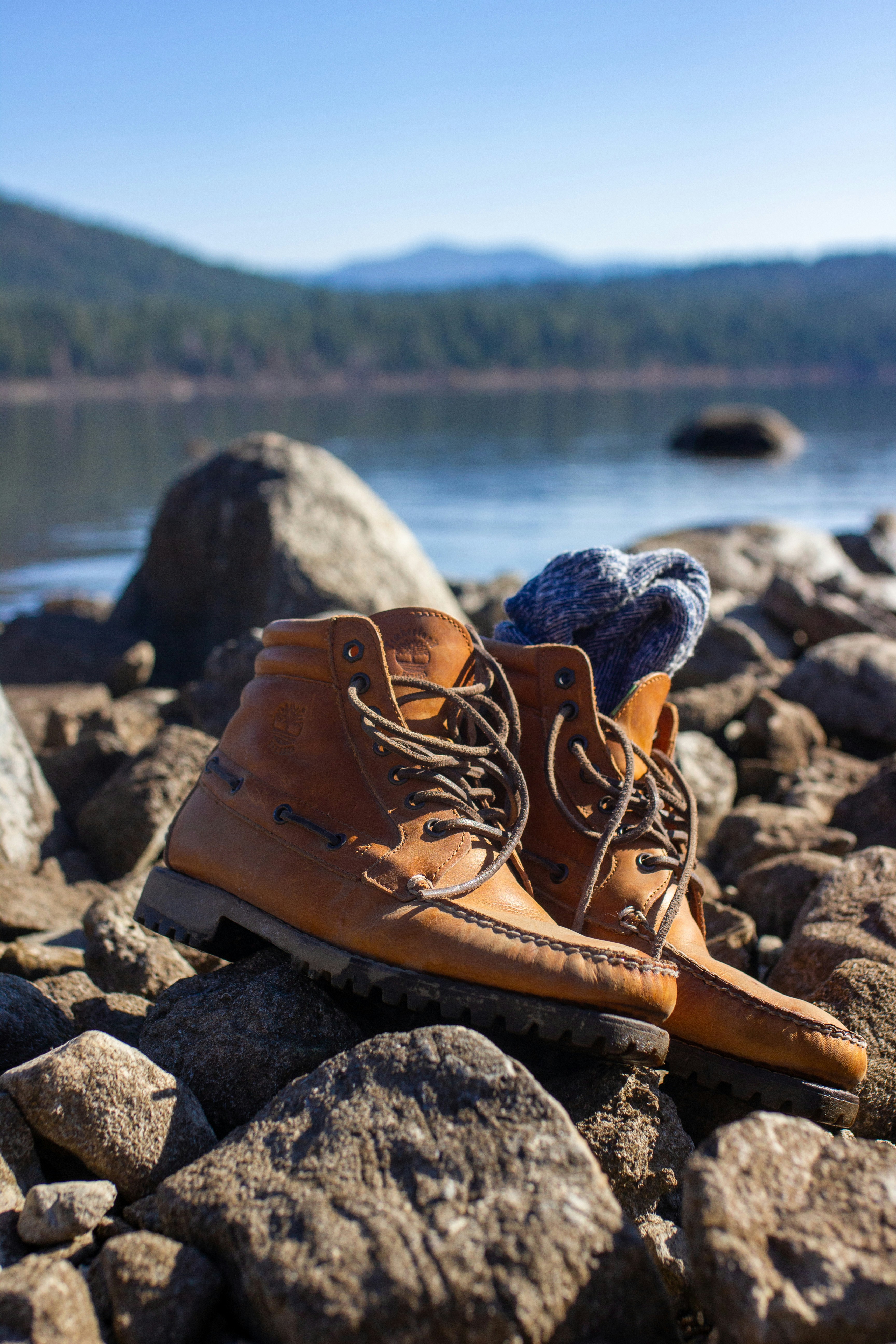 A pair of shoes on rocks by water photo – Free Usa Image on Unsplash