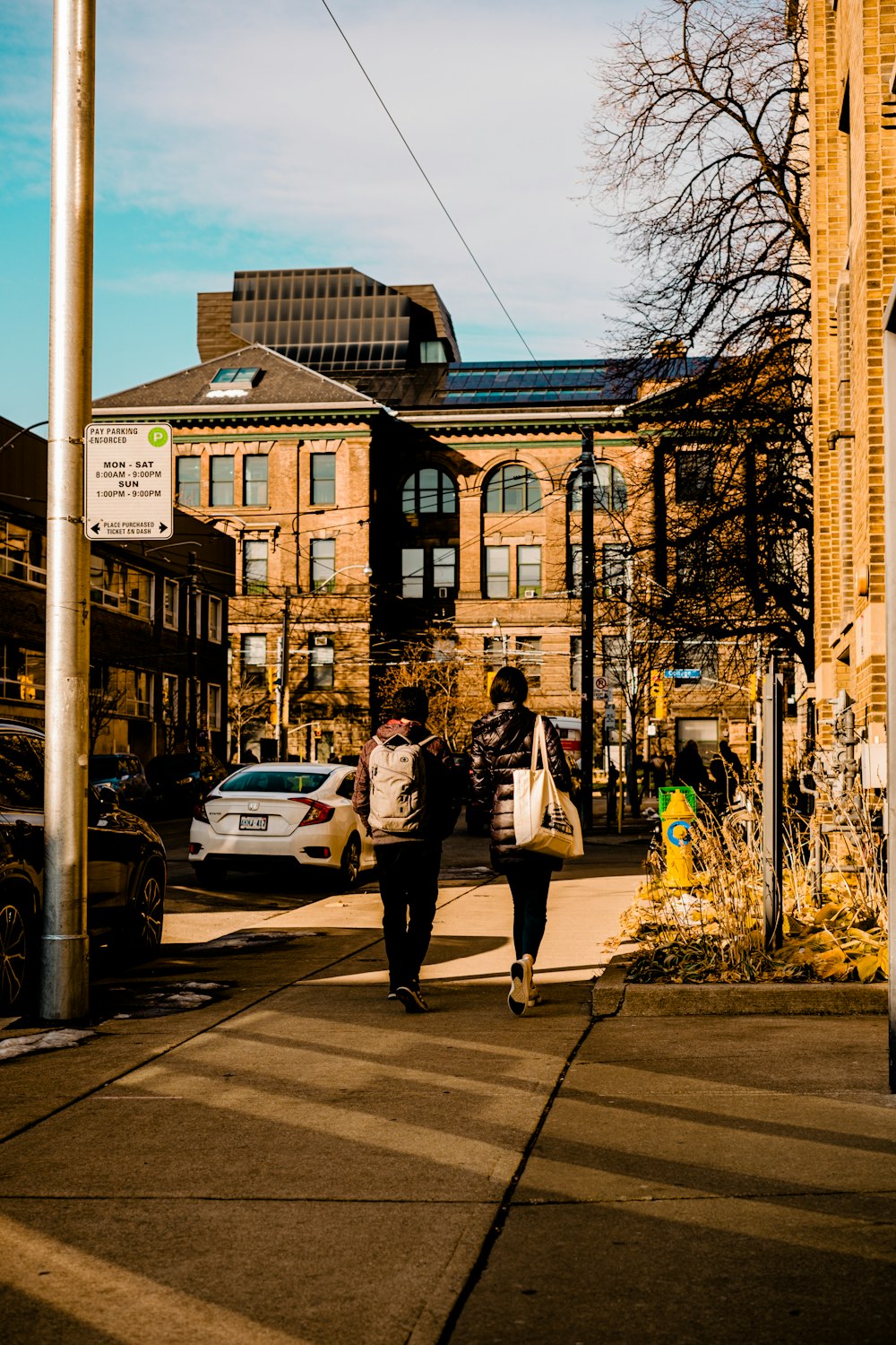 a man and woman walking down a sidewalk