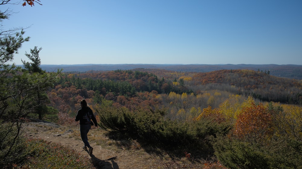 a man walking on a trail in the woods