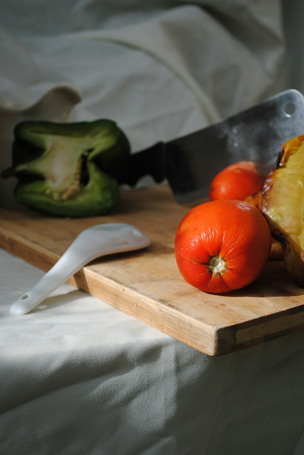 a knife and a cutting board with fruit on it