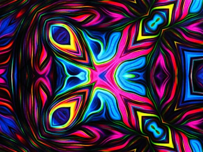 An intricate, symmetrical pattern that resembles a kaleidoscope. Vibrant colors including blues, pinks, and yellows swirl and blend together, creating a dynamic and psychedelic visual effect. The design features layered geometric shapes and curves, giving a sense of depth and movement.