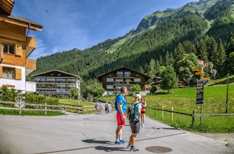 a group of people walking on a road in front of a mountain