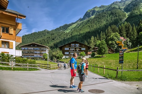 a group of people walking on a road in front of a mountain