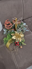 A table centerpiece featuring candles, pine branches, and ornaments glowing softly.
