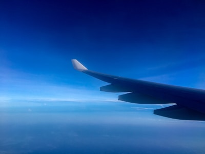 Close-up of an airplane wing with clear blue sky in the background.