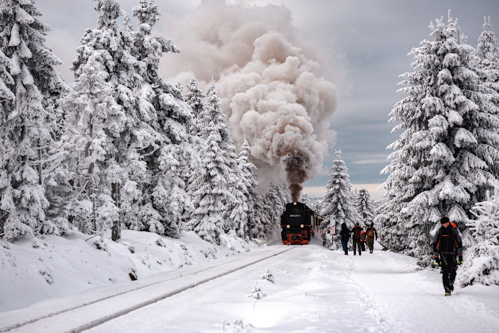 a train on a track with people walking on the side