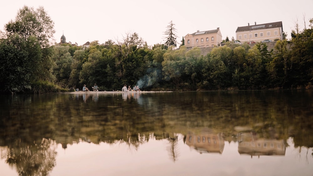 a body of water with trees and buildings in the background