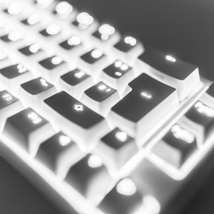 A sleek modern keyboard with glowing keys on a wooden desk.