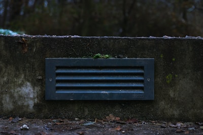 Close-up of a freshly installed amber resin vent on a crawl space foundation.