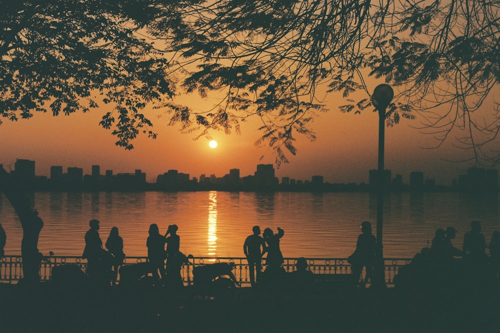 a group of people standing on a dock by a body of water