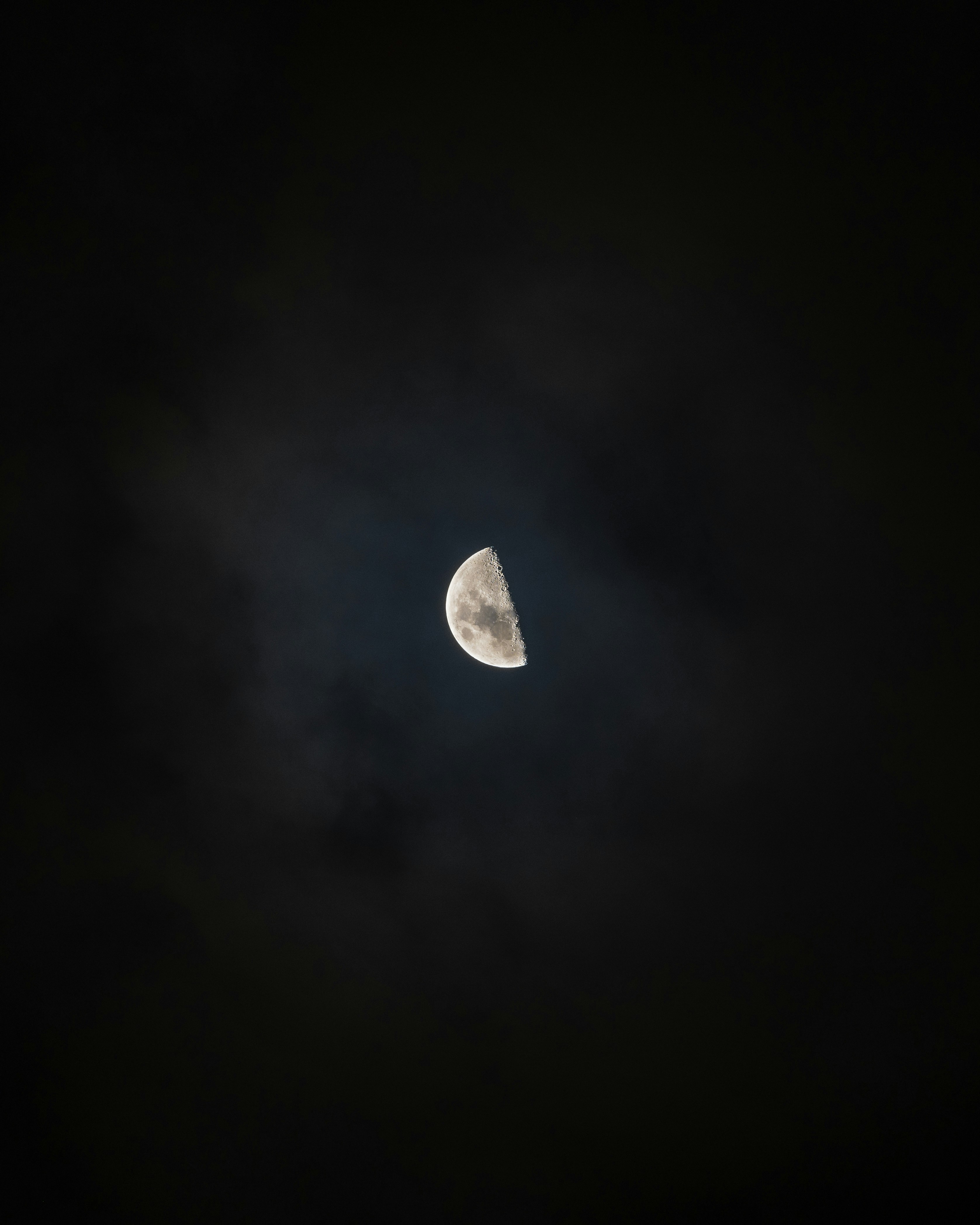 cratery last quarter moon slightly illuminating a dark, starless sk