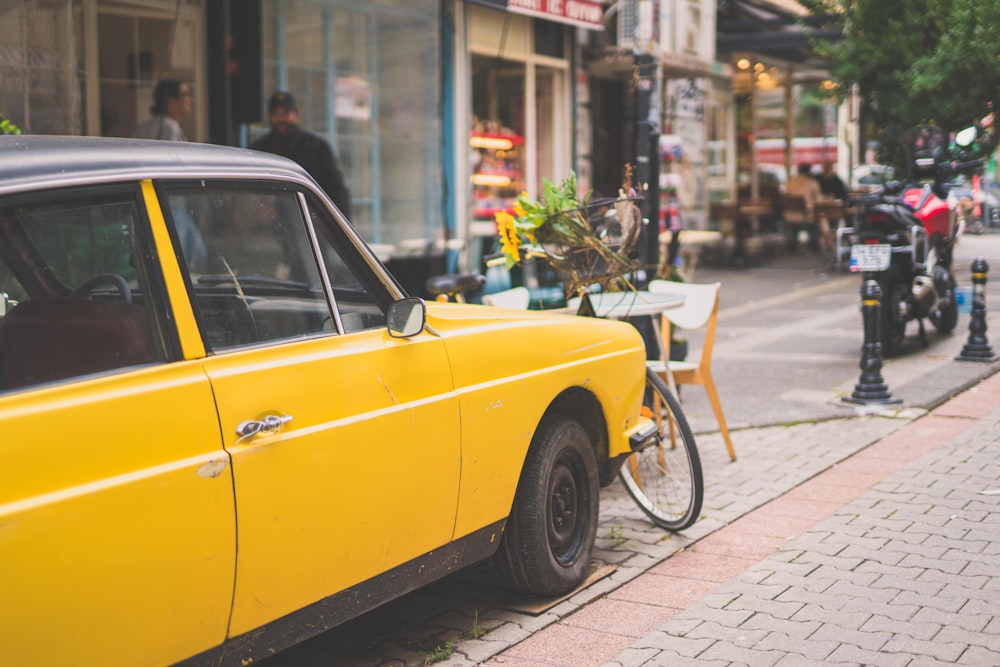 Un coche amarillo con una bicicleta en el capó