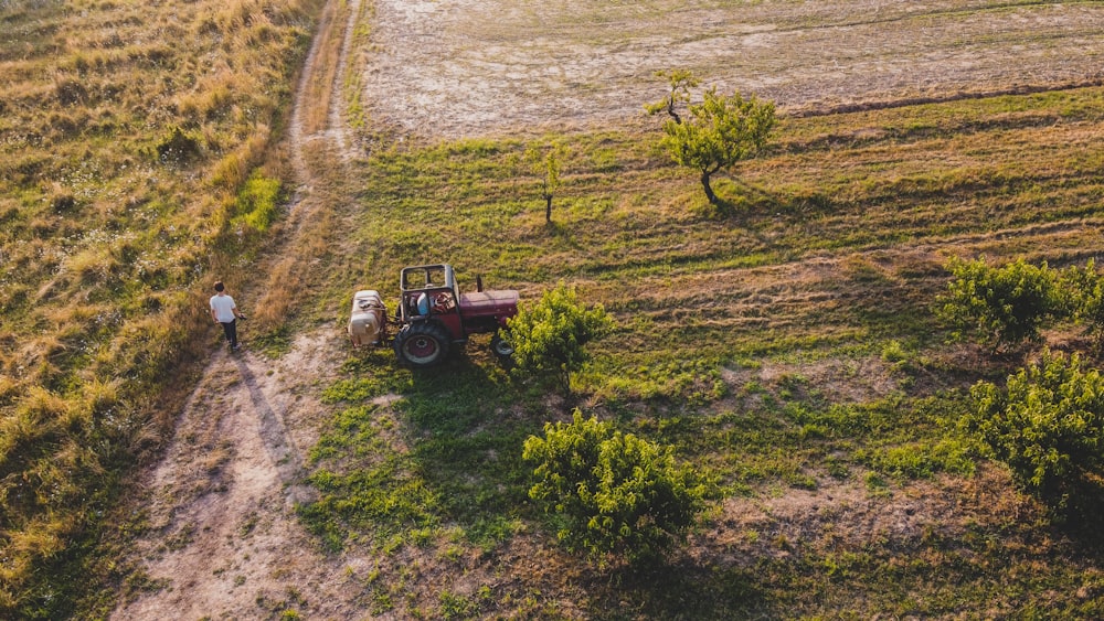 a person standing next to a tractor in a field
