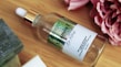 Elegant dropper bottle with clear serum surrounded by fresh botanicals