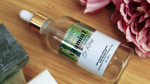 Elegant vitamin E serum bottle resting on traditional Indian fabric with vibrant patterns.