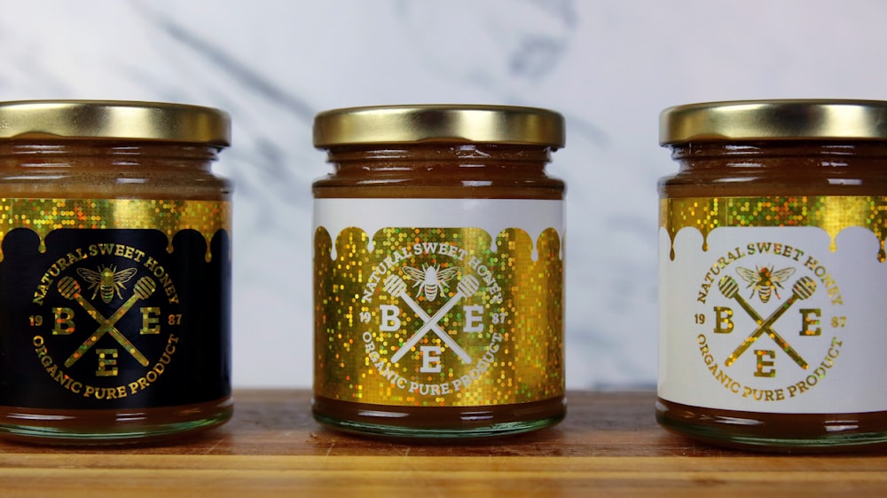 a group of jars with gold labels