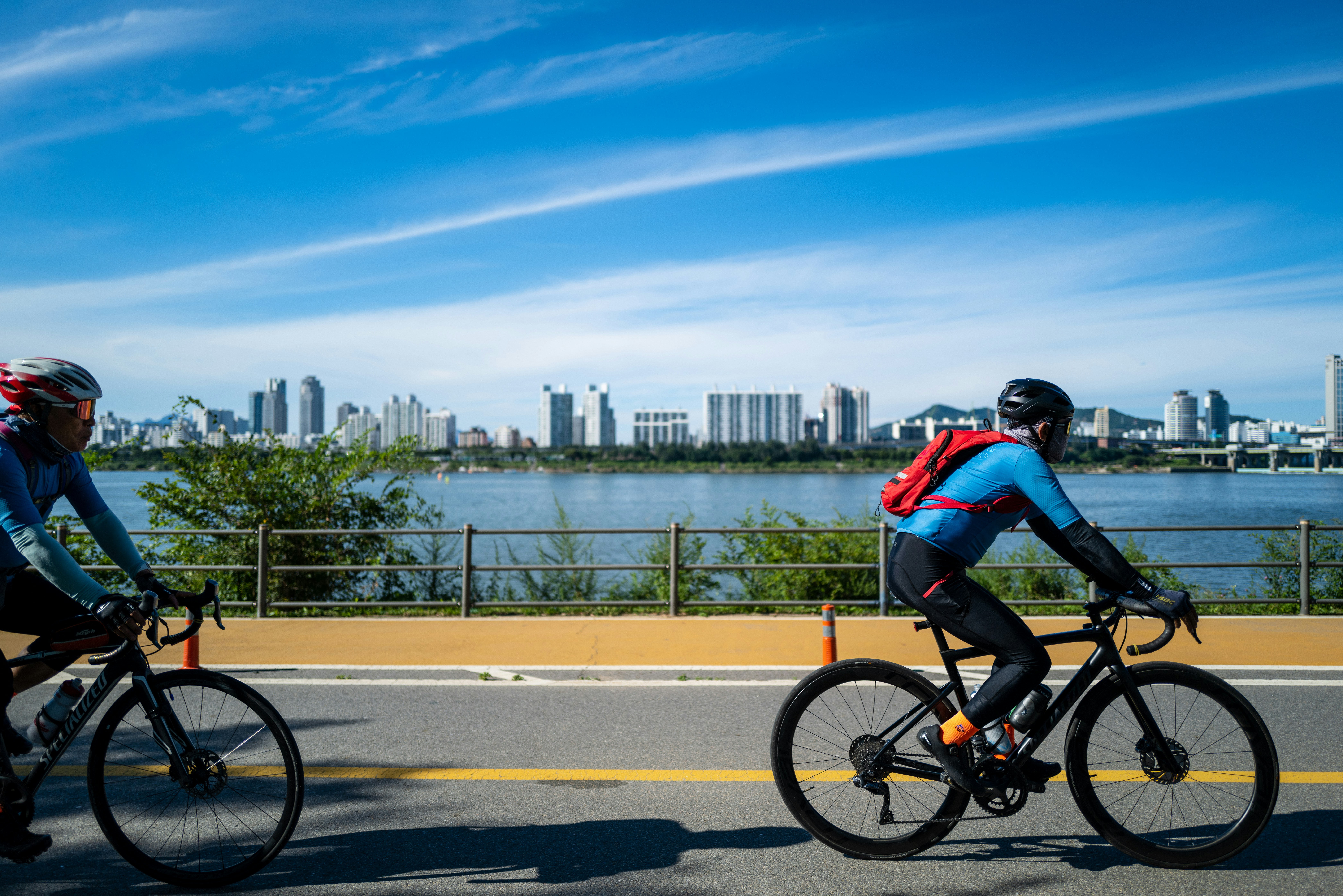 two people riding bikes on a road