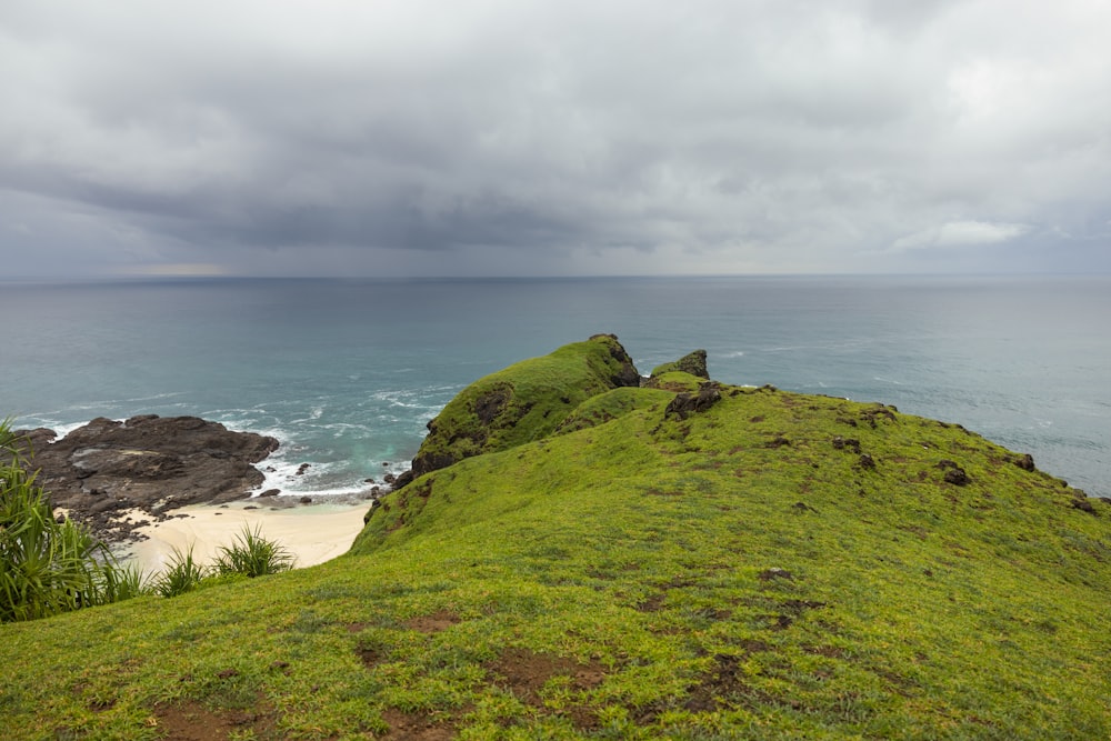 a grassy hill overlooking a body of water