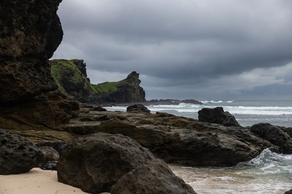 a rocky beach with a cloudy sky