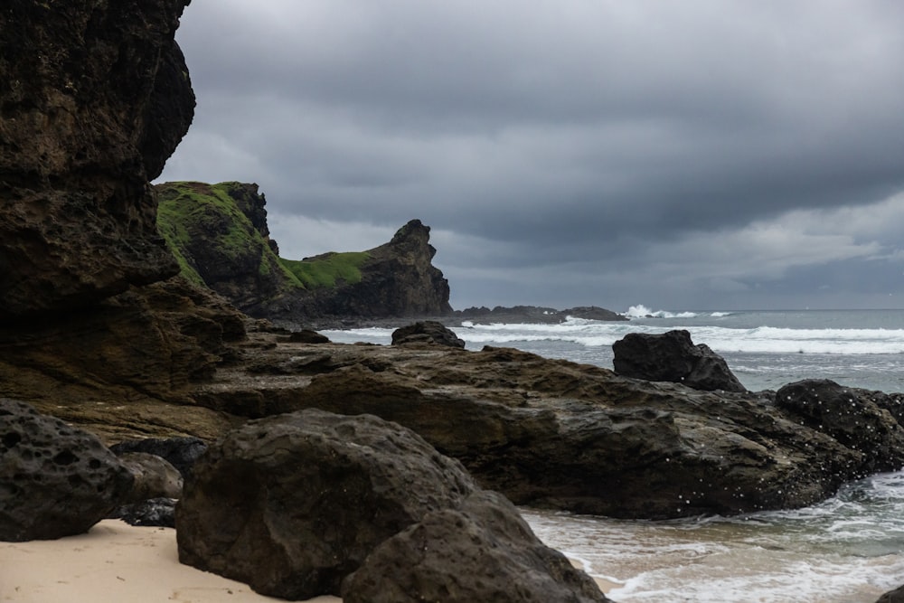 a rocky beach with a cloudy sky