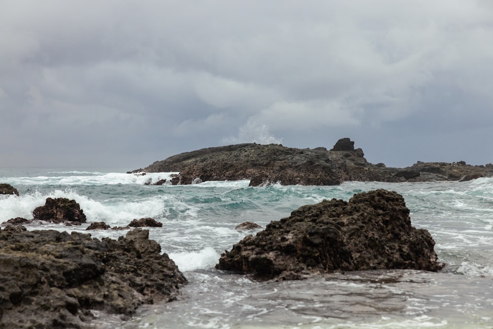 a rocky beach with waves crashing against it