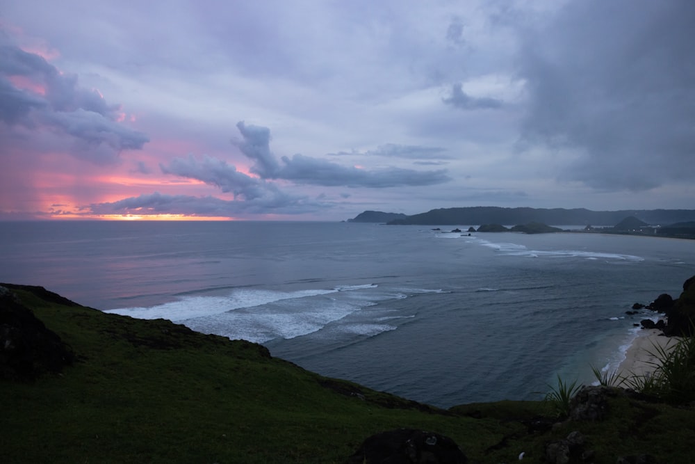 a beach with a body of water and a sunset