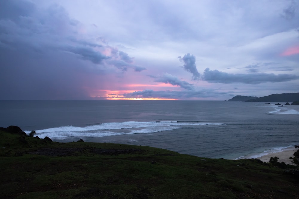 a beach with waves and a sunset