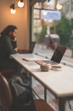 a person sitting at a table with a laptop