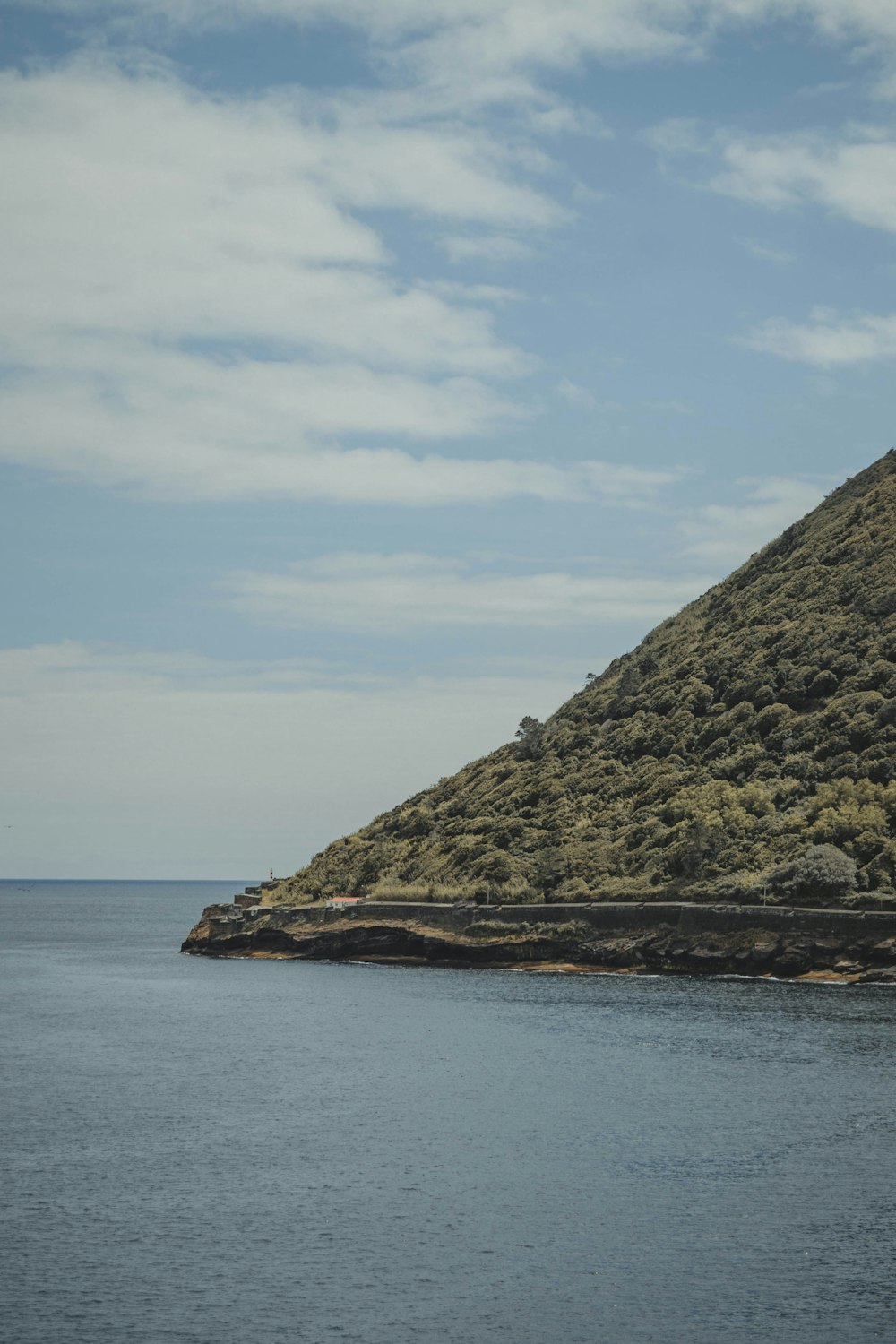 a rocky cliff next to a body of water