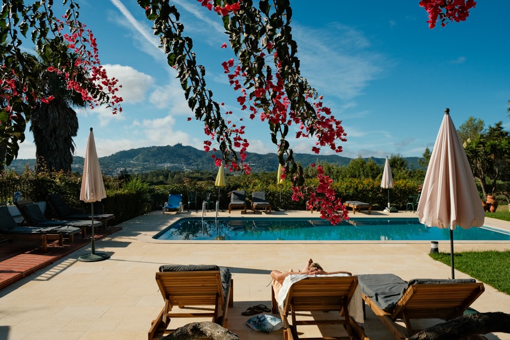 a pool with chairs and umbrellas next to it