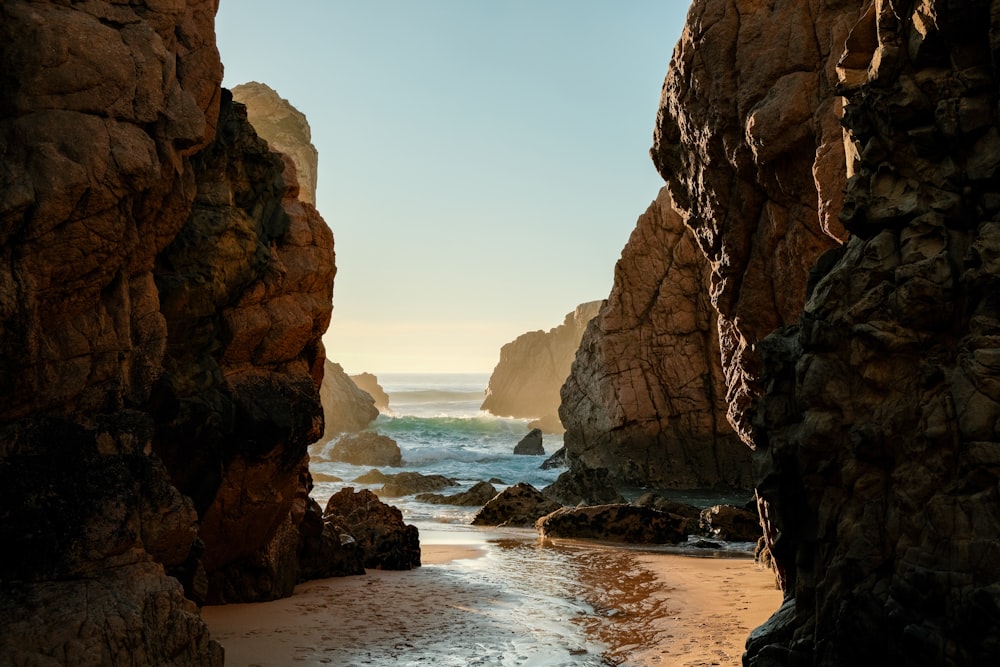 a rocky beach with a body of water in the background