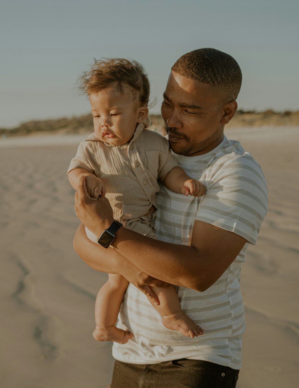 a person holding a baby on a beach
