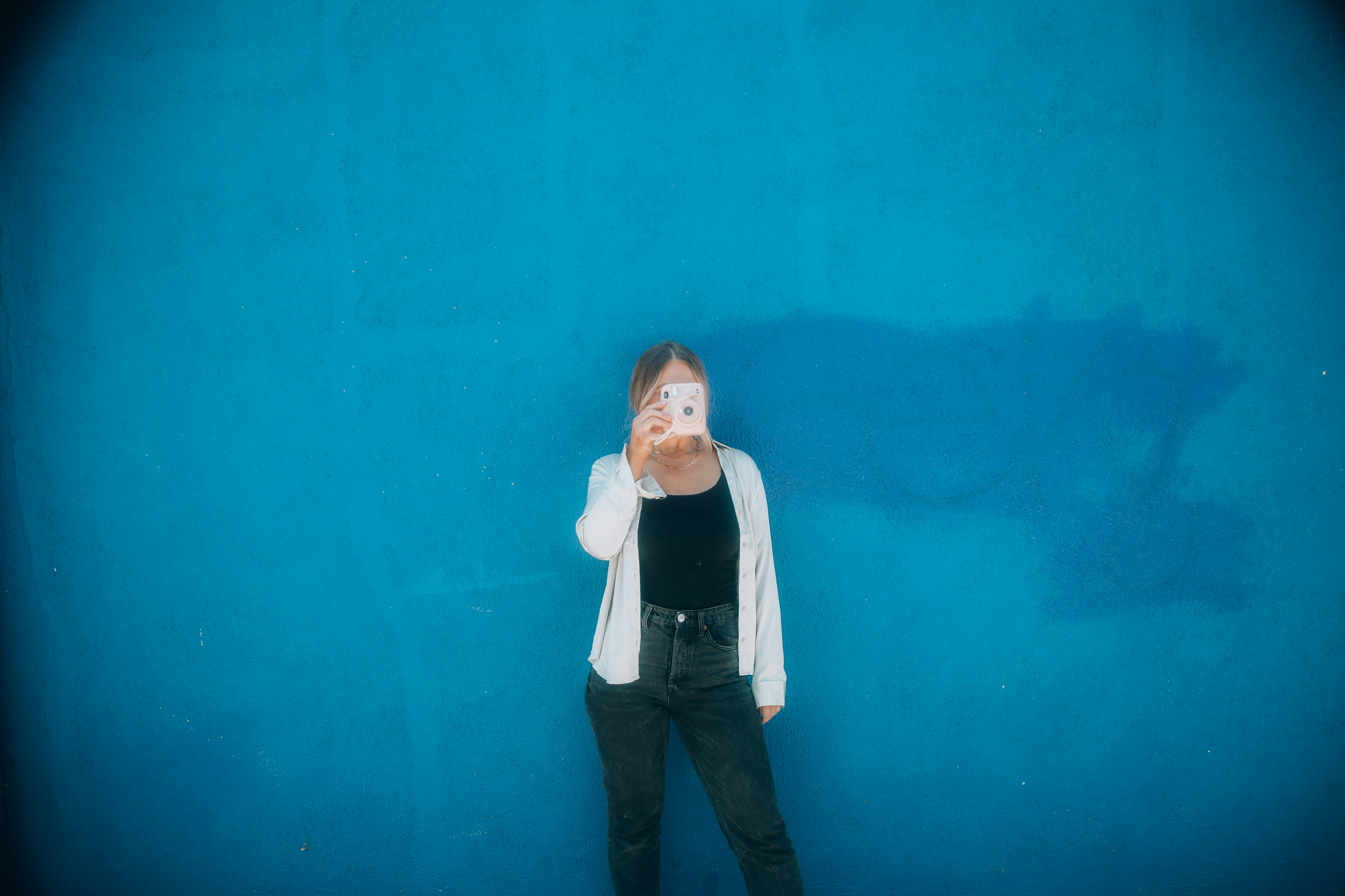 a person standing in front of a blue wall