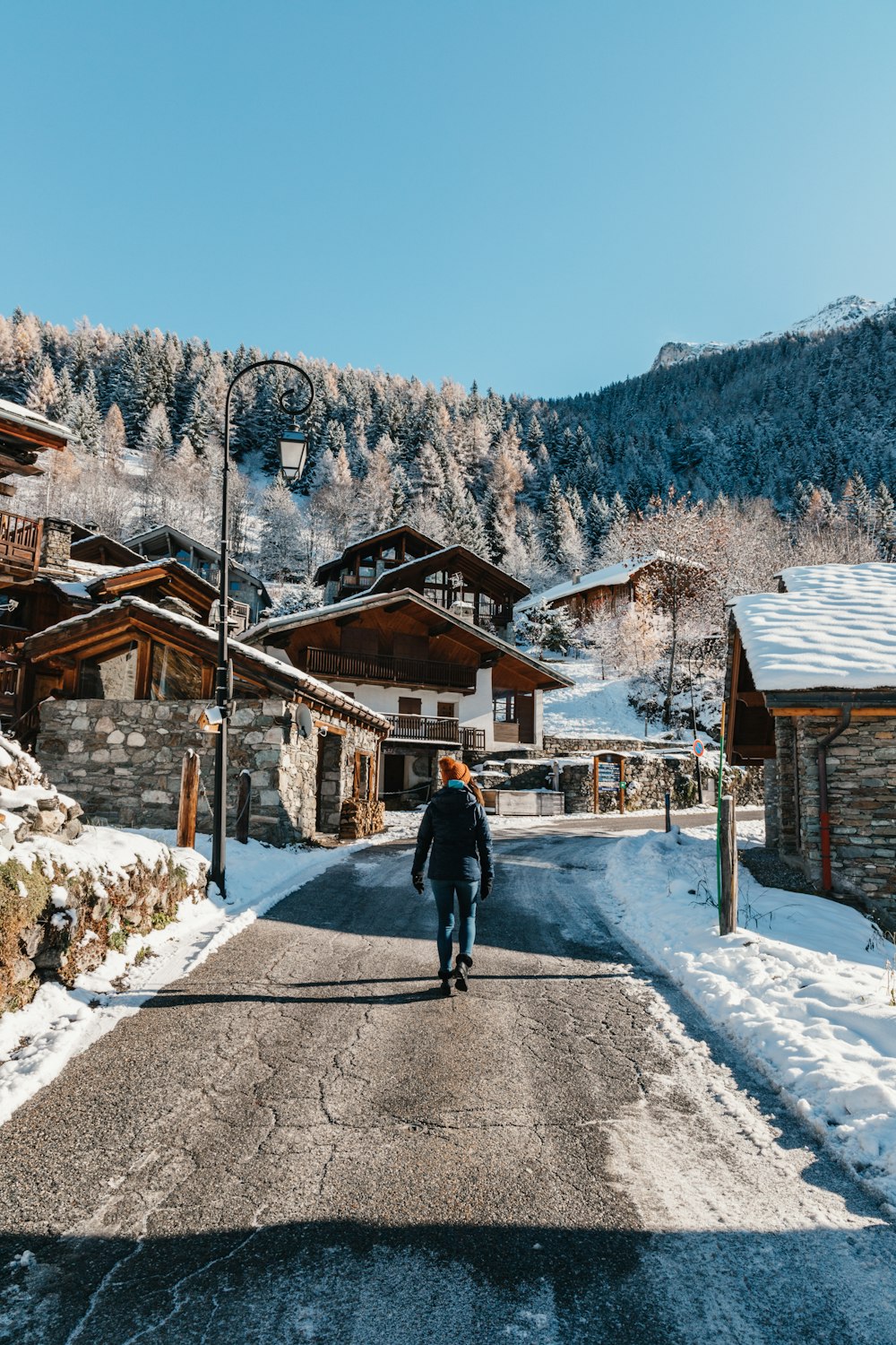 a person walking on a road with buildings on the side