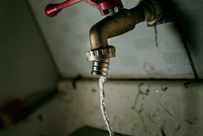 Close-up of a handyman fixing a leaking faucet in a cozy kitchen.
