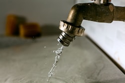 a water droplet pouring water into a faucet