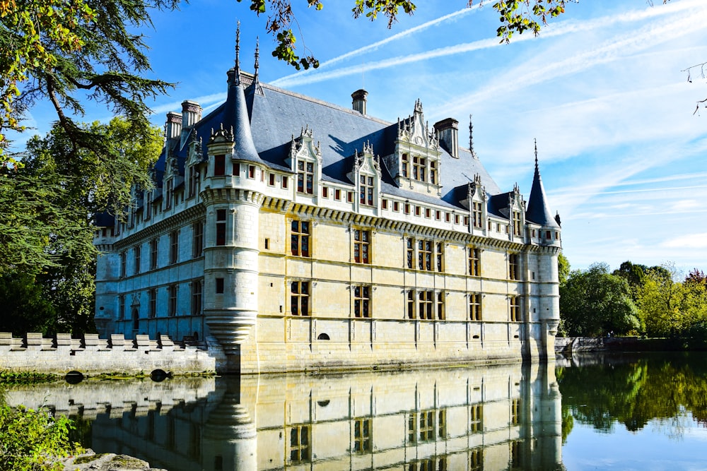 a large building with a moat with Château d'Azay-le-Rideau in the background