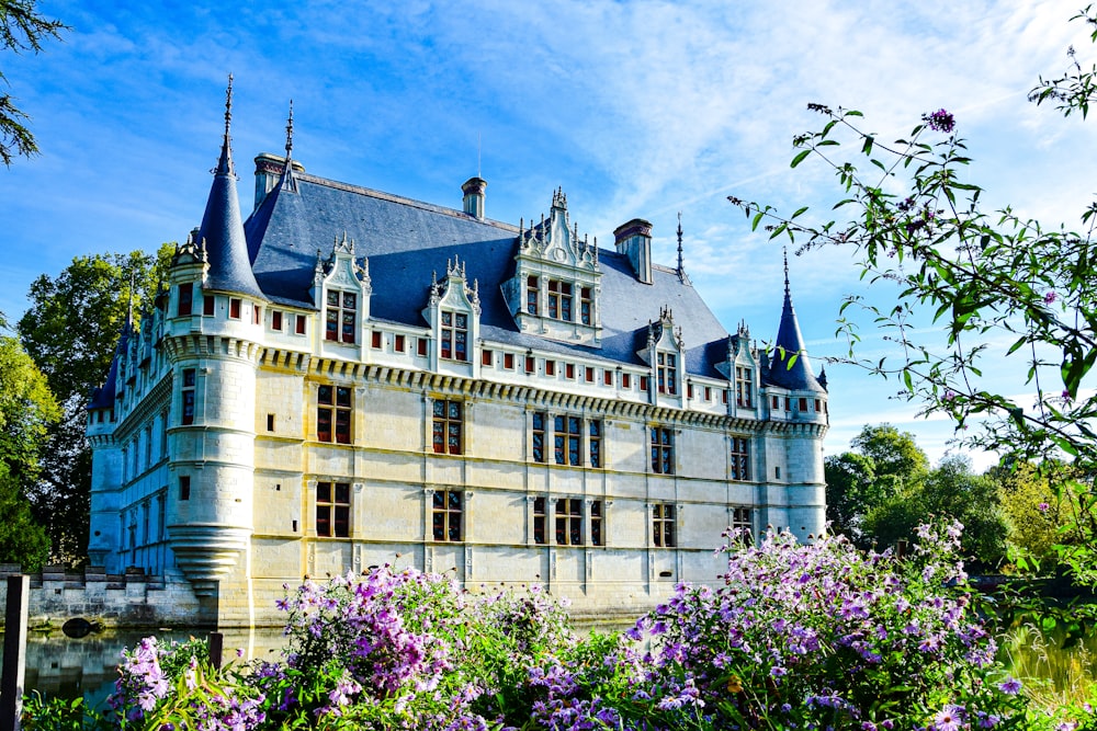 a large white building with blue spires and trees in front of it