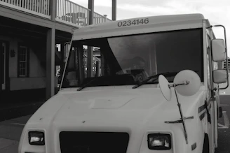 A Hibbard Deliveries box truck parked outside a warehouse, ready for loading.
