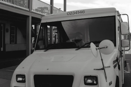 A Hibbard Deliveries box truck parked outside a warehouse, ready for loading.