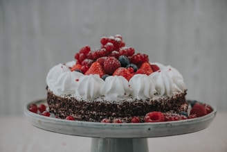 a cake with white frosting and berries on top