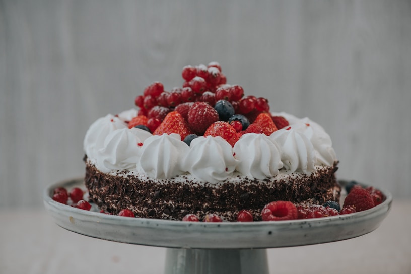 a cake with white frosting and berries on top
