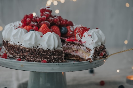 A close-up of a beautifully decorated layered cake with fresh berries on top.