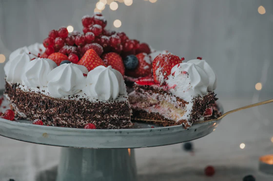 Close-up of a beautifully decorated chocolate cake with fresh berries on top.