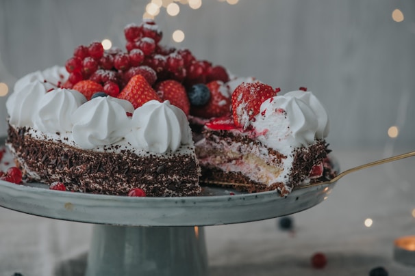 A close-up photo of a beautifully decorated chocolate cake with fresh berries on top.